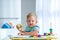 A little boy 2 years  eats an apple and is played with wooden balls. Educational logic toys for children. Montessori games for