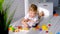 A little boy 2 years old lies on the floor and collects a wooden pyramid. Educational logical toys for children. Montessori games
