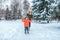 Little boy 3-5 years old, skiing in winter in a snowy forest. A young mother walks in the back. Active skiing, nature on