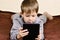 Little boy 5 years lying and playing on a tablet
