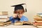 Little boy in academic hat studies an old books with magnifier