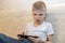 Little boy is angry that his parents take phone. game dependency problem concept