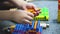 A little boy assembles a colorful house from the details of the designer. Development of fine motor skills.