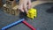 A little boy assembles a colorful house from the details of the designer. Development of fine motor skills.