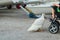 A little boy in a baby stroller feeding a goose with bread at dusk in the port