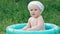 Little boy baby swimming in the inflatable pool and smiling