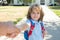 Little boy with backpack holding parent fathers hand on blurred school building background. Child with rucksacks