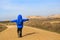 Little boy with backpack travel on the road to scenic mountains