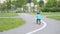 Little boy in bicycle safety helmet learns to ride a balance bike on a traffic playground