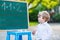 Little boy at blackboard learning to write