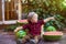 A little boy with blond hair n the summer on a sunny day sitting at a gazebo with a green grapes and eating a watermelon