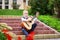 Little boy blond sits on steps in front of school and plays acoustic guitar. Boy learns to play guitar and sing. Concept