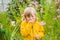 Little boy is blowing his nose on green meadow near flowers. Flower allergy concept