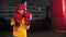 Little boy boxer hitting a big punching bag on training