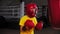 Little boy boxer punching a big punching bag on training