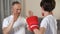 Little boy boxing with his step-father, learning attacking, family togetherness