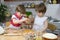 Little Boy Breaking an Egg in Mixing Bowl and His Brother Helping Him