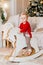 little boy with bruise under eye in red Christmas sweater on rocking horse