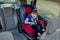 Little boy buckled up with seatbelt inside the car. Vehicle and transportation concept