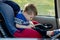 Little boy buckled up with seatbelt inside the car. Vehicle and transportation concept