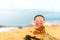 Little boy Buddhist, little Buddha, sitting on the sand on the beach . Rejoice and smiles in the Lotus position. Meditation and