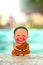 Little boy Buddhist, little Buddha, sitting on the sand by the pool at the hotel. Rejoice and smiles in the Lotus position.