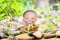 Little boy Buddhist, little Buddha, sitting on the sand on stones and green grass background. and smiles in the Lotus position.