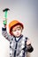 Little boy in builder helmet holding toy hammer