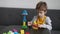 Little boy building constructor tower of colorful wooden blocks at home. Educational logical toys for children. Montessori games