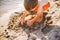 A little boy builds figures from the sand on the shore of the pond at sunset of the day, hands dig up the sand in crisp plan