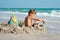 A little boy builds a sand castle. Playing with sand and toys for the ocean. A holiday with the kids at the resort.