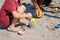 A little boy builds a sand castle. Playing with sand and toys for the ocean. A holiday with the kids at the resort.