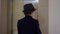 Little boy in business suit, hat and briefcase comes into elevator back view. Businessman pushing button for calling