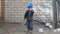 Little boy with camera and bread outdoors near wall