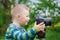 Little boy with an camera shooting outdoor