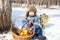 Little boy in a cap with earflaps plays winter park