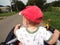 Little boy in cap explores street riding