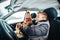 Little boy in the car as a driver and small girl near her as a passanger