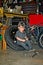 Little boy in a car mechanic uniform sits in a tire