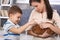 Little boy caressing pet rabbit handheld by mum