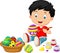 Little boy cartoon painting an Easter egg