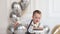 Little boy celebrating birthday, child has a B-day party. Boy blowing candles on the birthday cake. Celebration, white