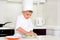 Little boy chef cleaning his plates while cooking