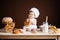 Little boy in chef costume with buns and bread is sitting on the table