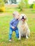 Little boy child kissing Golden Retriever dog on grass