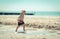 Little boy child walking on the beach inspecting a shell