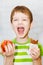 Little boy chooses chocolate or apple on a light background in the st