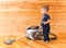 Little boy cleaning wooden floor with hoover