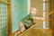 Little boy climbing on indoor wooden slide