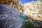 Little boy climbing natural boulder